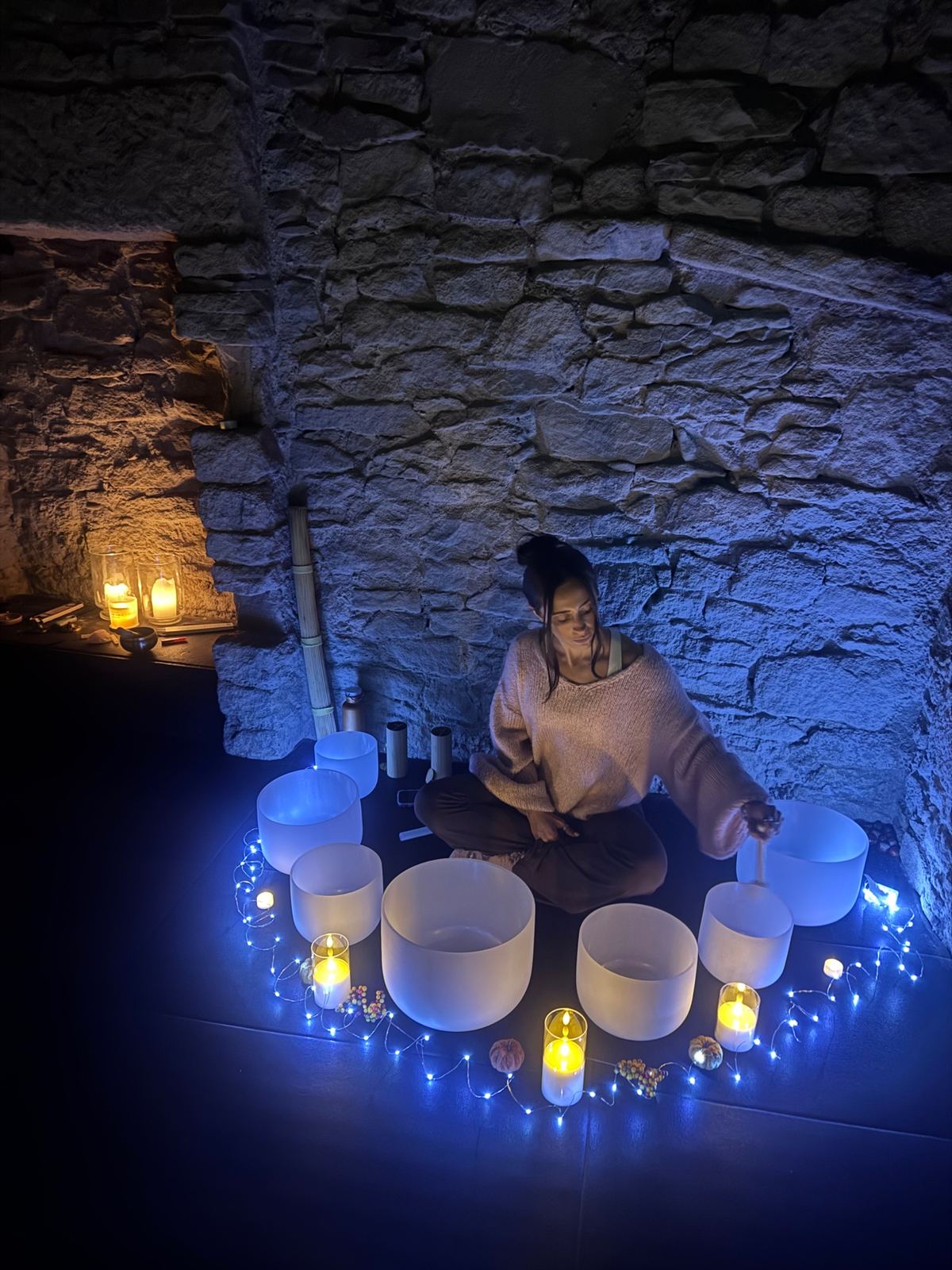 Crystal singing bowls surrounded by candlelight for a sound bath